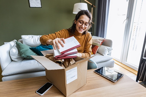 Young woman holding books she bought online